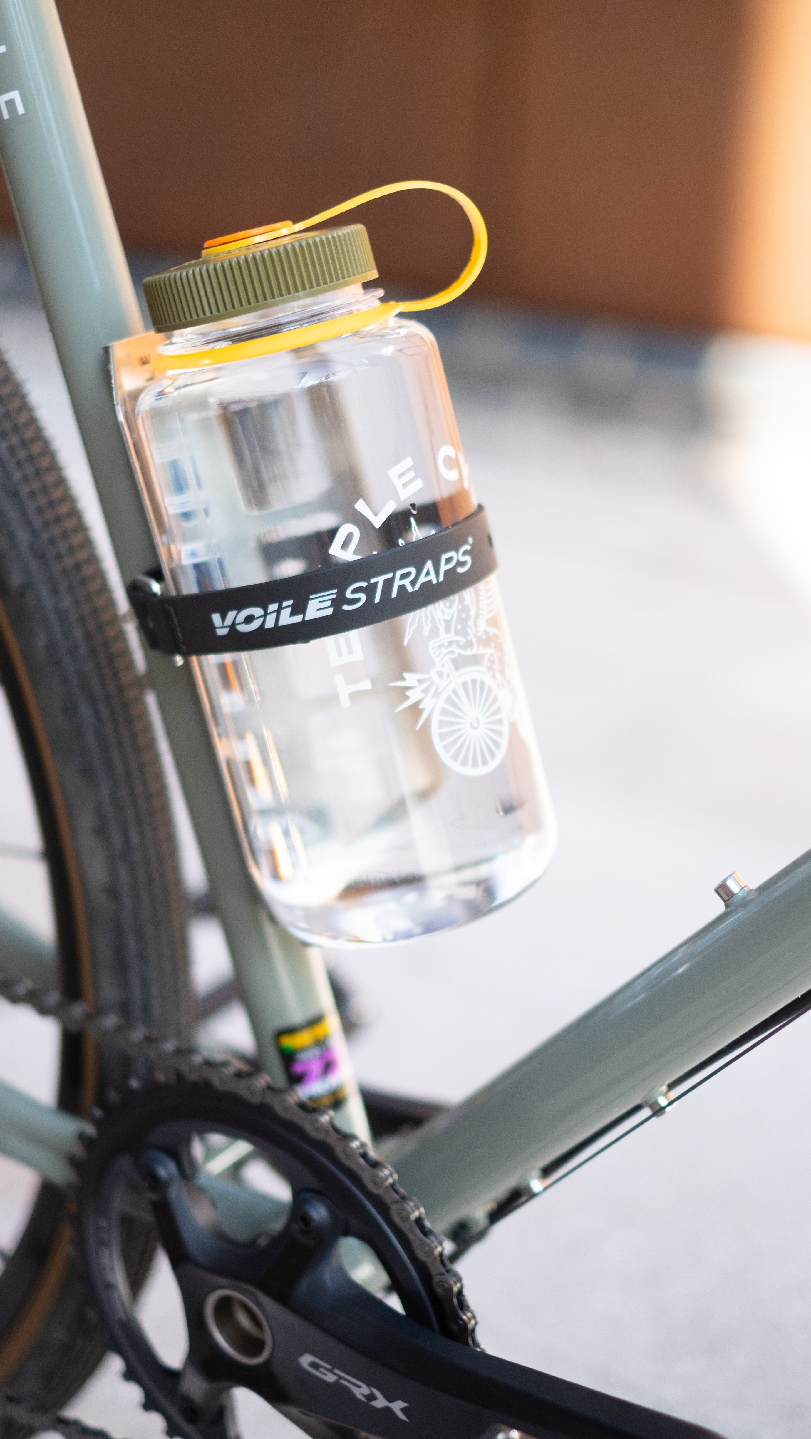 Large Nalgene bottle secured to a Temple Cycles bike frame using a Voile strap.
