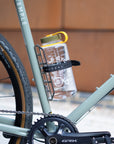 Adventure bike with GRX crankset and Nalgene bottle mounted in a cargo cage on the down tube, secured with a Voile strap.