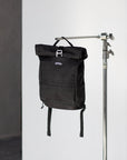 Black backpack for a pannier bike rack in a studio setting.