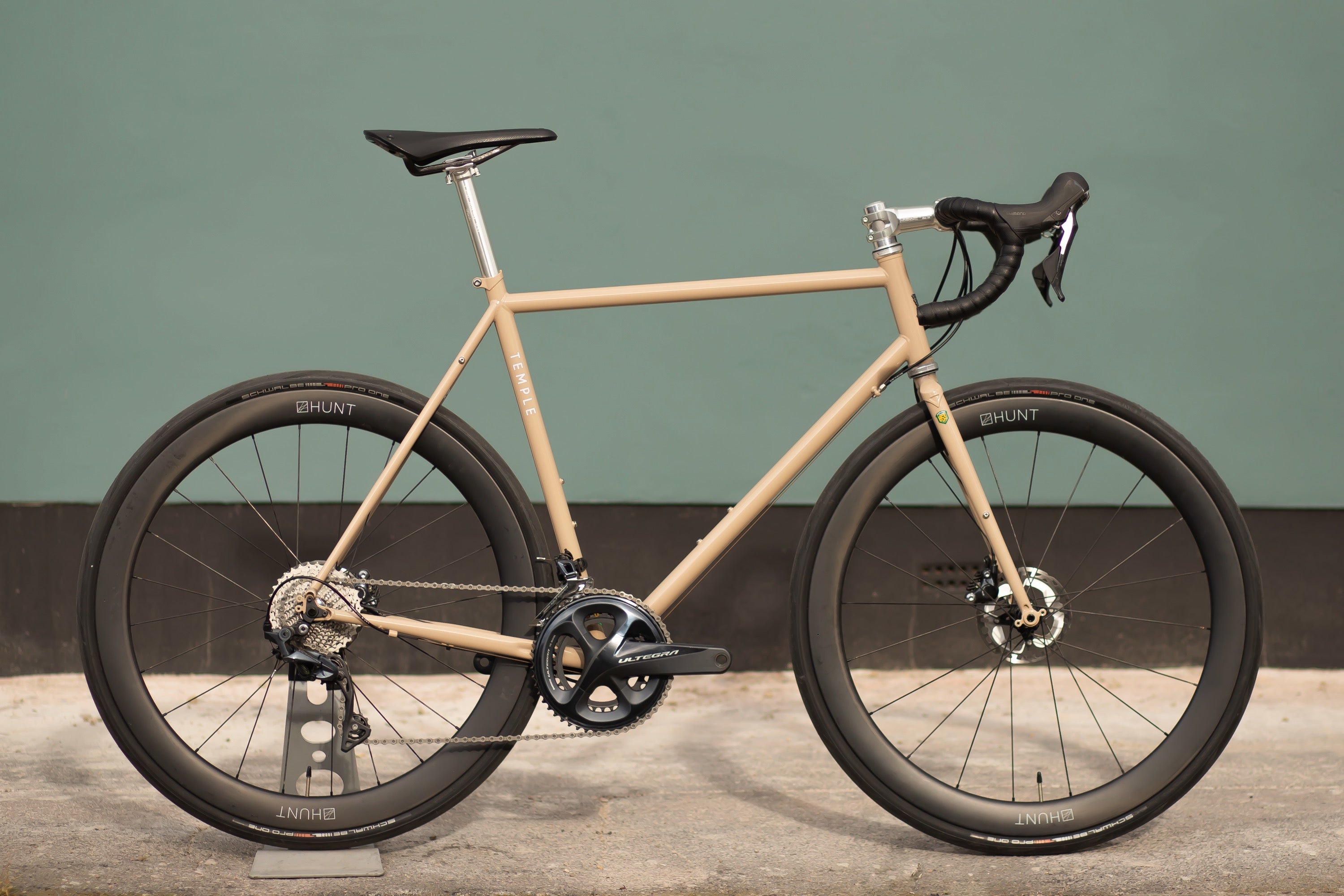 Sand coloured lightweight road bicycle, urban setting.