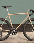 Sand coloured lightweight road bicycle, urban setting.