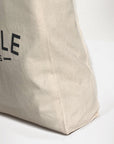 Women’s canvas tote bag with durable, heavyweight handles, studio setting.