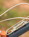 Close-up of stainless steel bottle cage mounted on a navy Temple Cycles bike.
