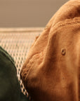 Brown and green super soft, organic cotton corduroy cap, in-door setting.