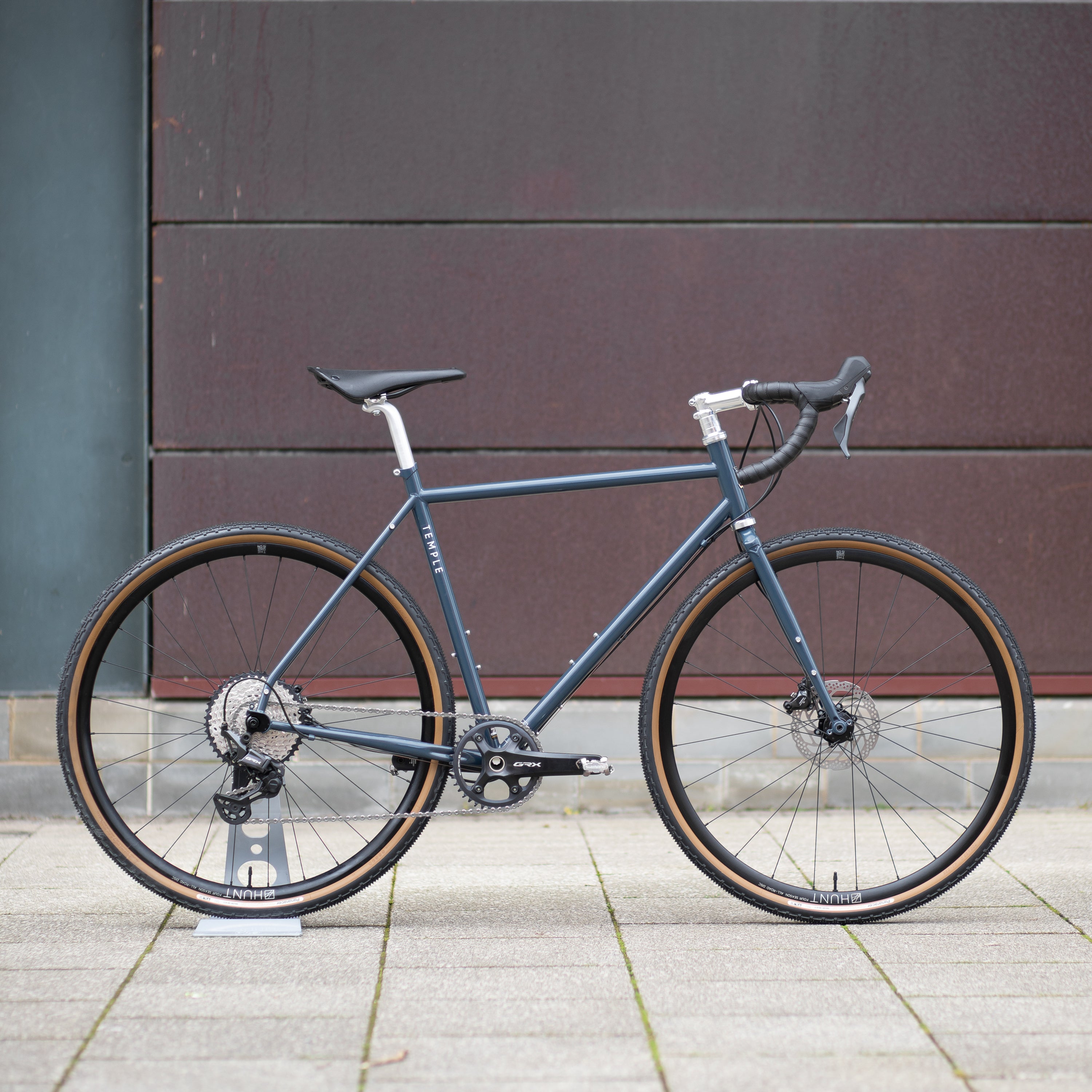 Blue steel gravel bike in an urban setting.