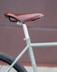 Brooks leather saddle on green steel framed gravel bike.