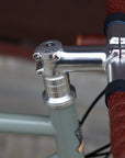 laser - engraved Temple Cycles head tube on a steel framed touring bike in lichen green.