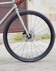 Front wheel handbuilt by Hunt on a green, lightweight steel bikepacking bike.