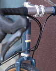 Temple handmade head badge beneath flared handlebars on a blue, steel, gravel bike.