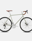 Green touring adventure bike with a lightweight steel frame, studio setting.