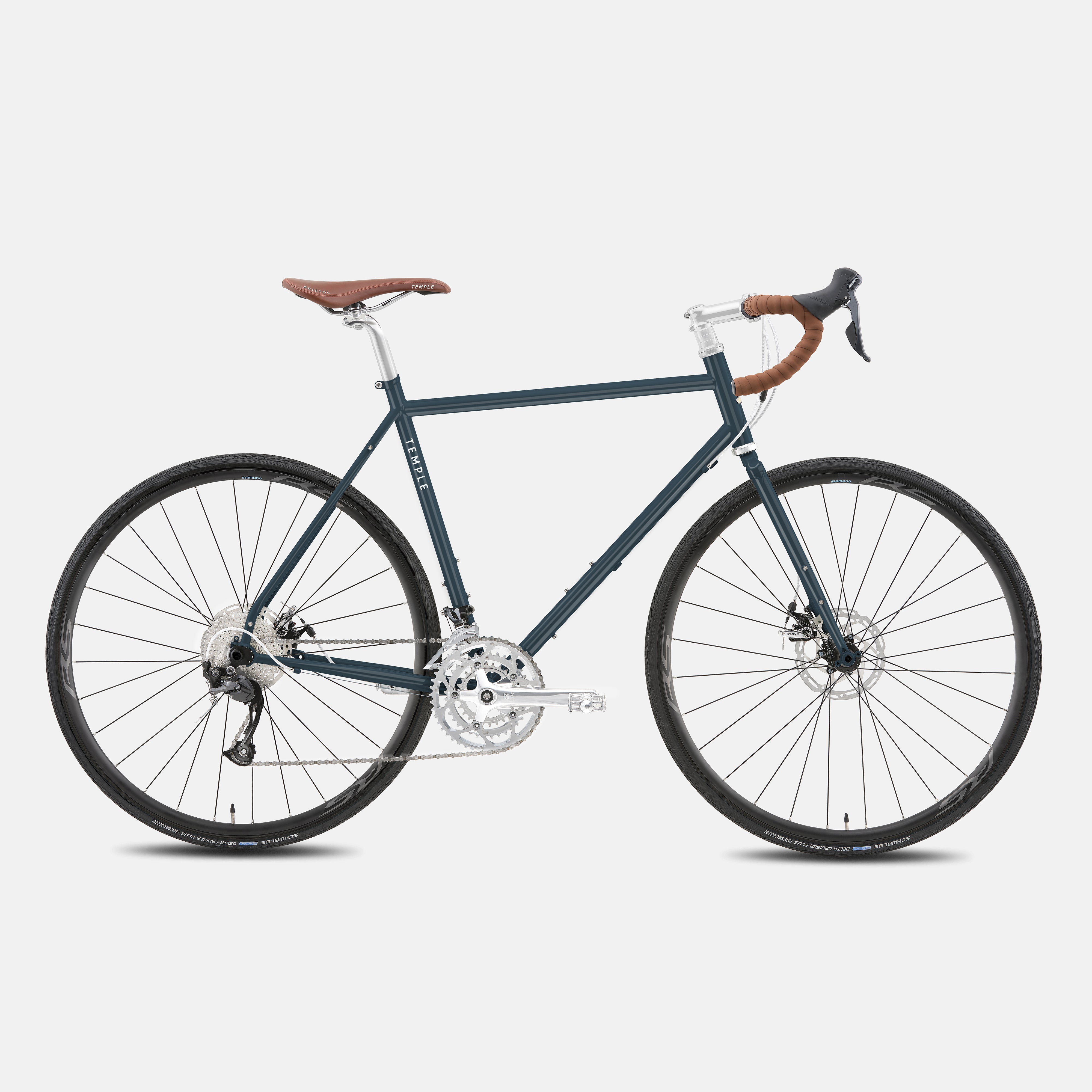 Touring gravel bike in a studio setting with a slate blue steel frame.