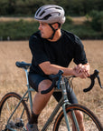Man riding a bicycle in a field wearing a helmet