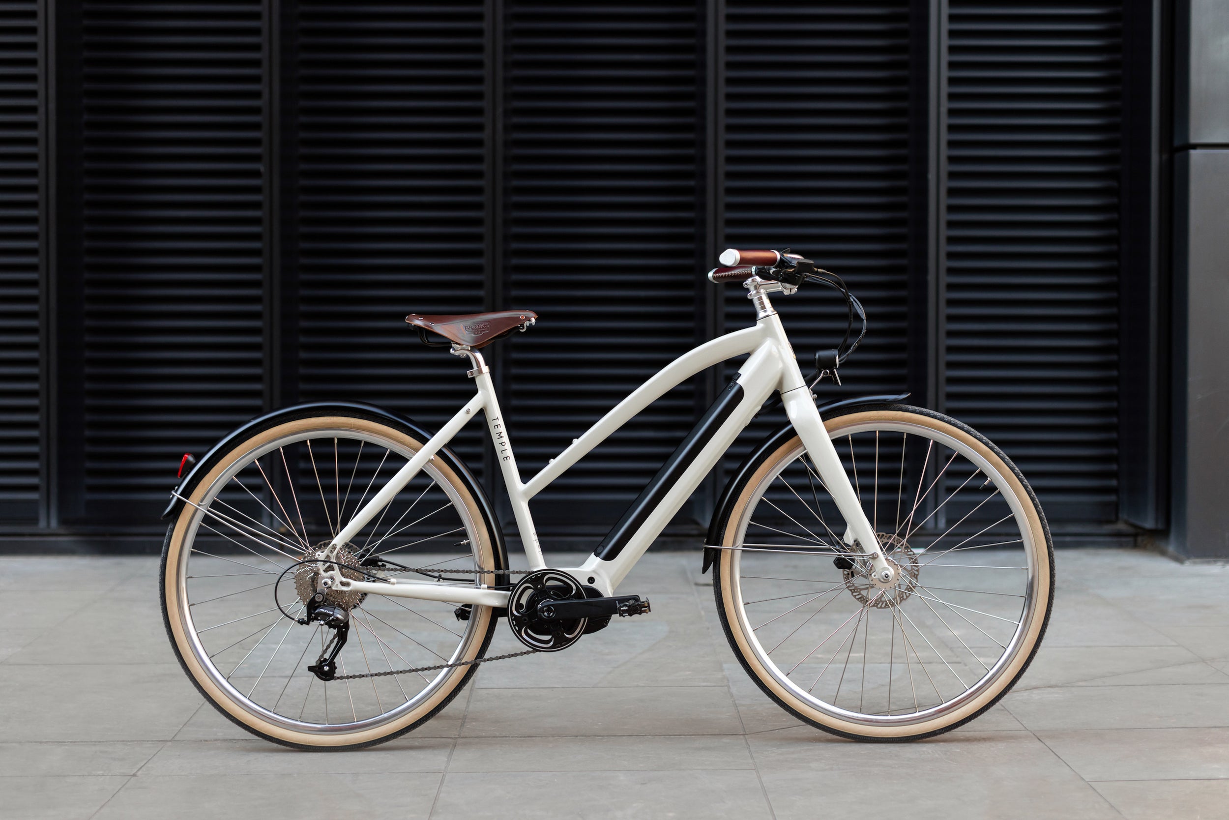 Cream Step Through Electric bicycle, urban setting.