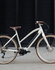 Cream Step Through Electric bicycle, urban setting.