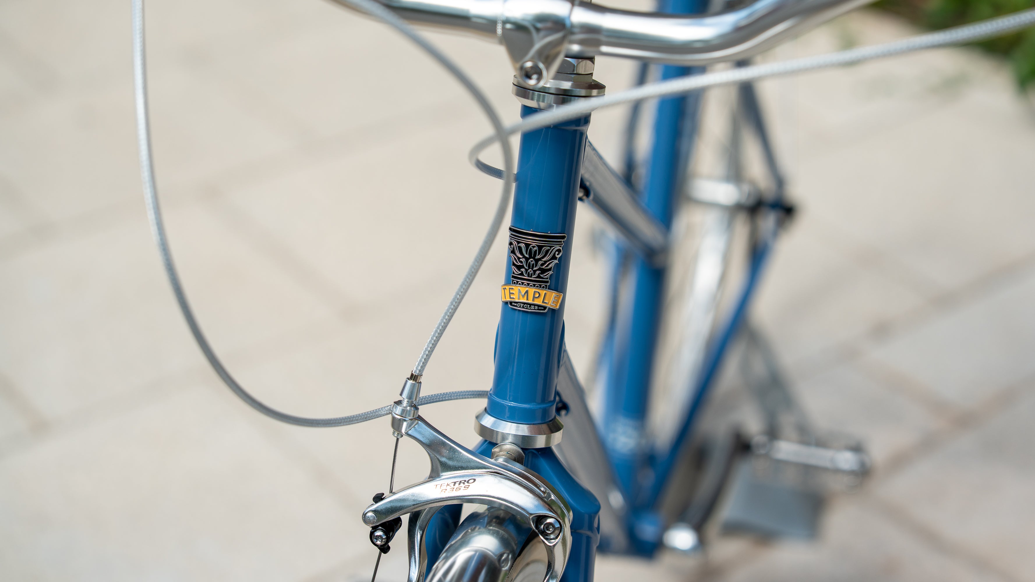 Front shot of Temple Cycles badge on a steel framed blue bike.