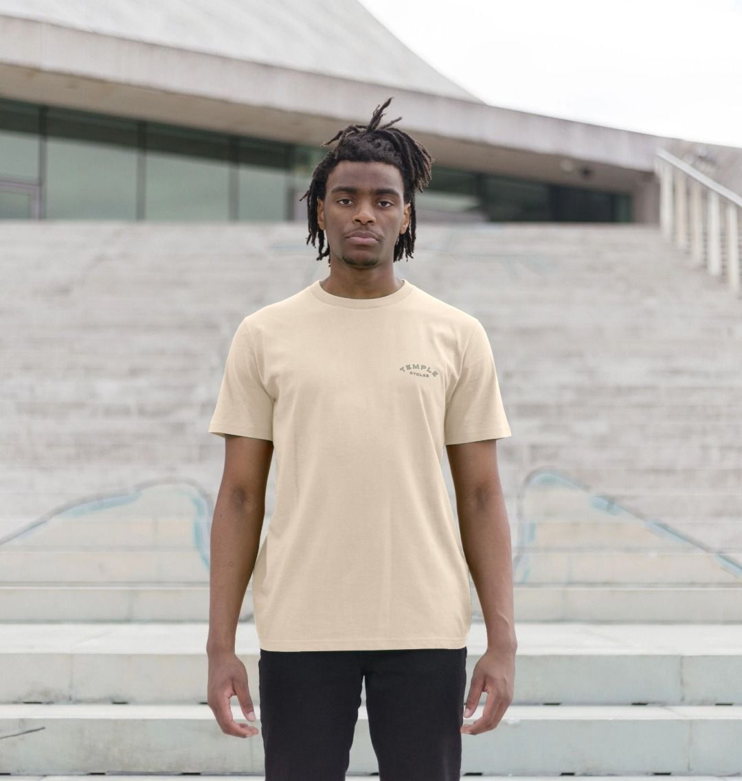 Male model wearing sustainable, off-white graphic tee, urban setting.