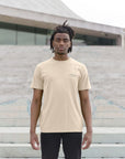 Male model wearing sustainable, off-white graphic tee, urban setting.
