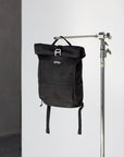 Black backpack for a pannier bike rack in a studio setting.