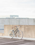 All-rounder leisure bicycle in blue, propped up in an urban setting.