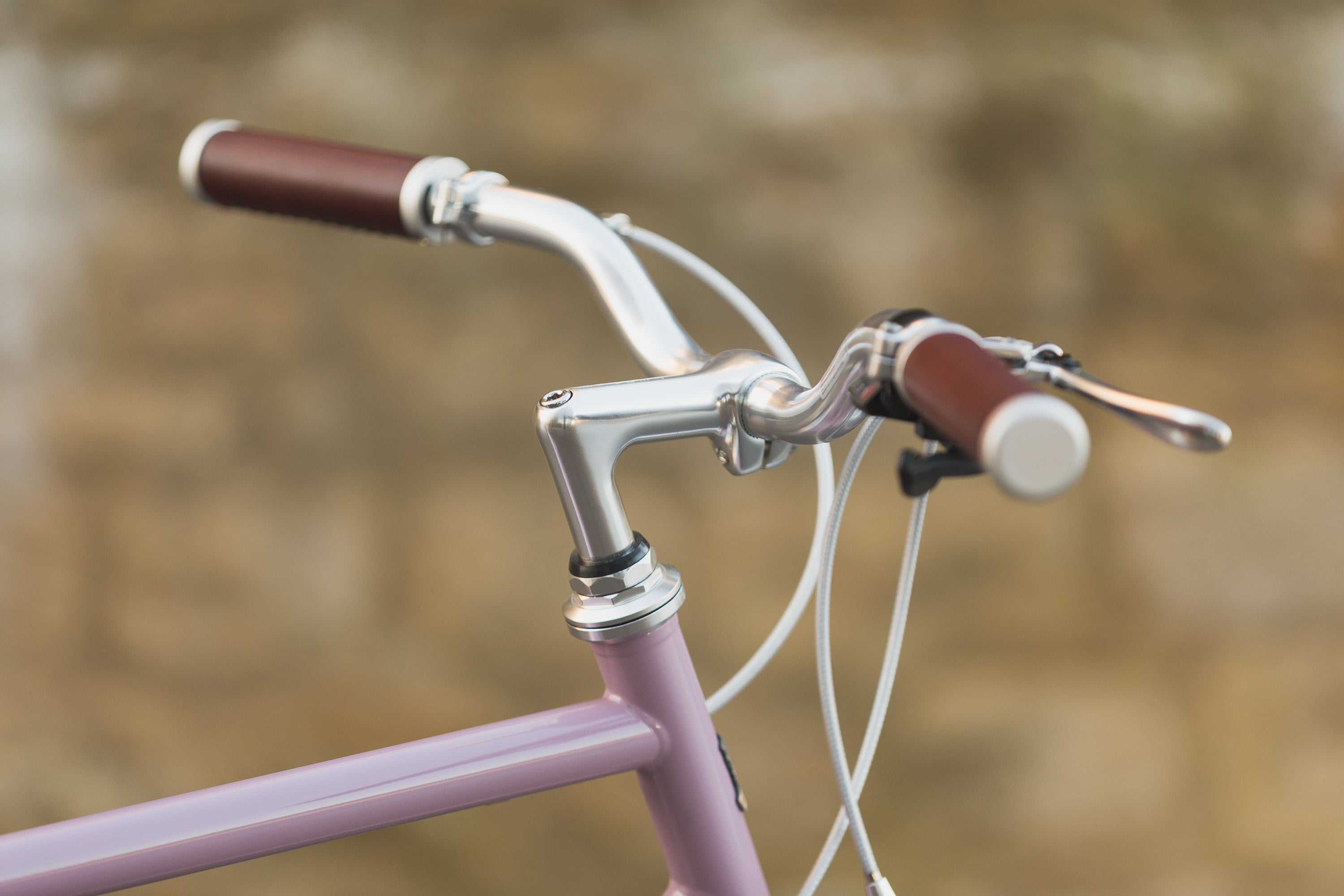 Classic handlebars on a pink steel-framed touring bike.