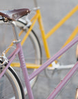 Books leather saddle on a steel commuter bike in pink.