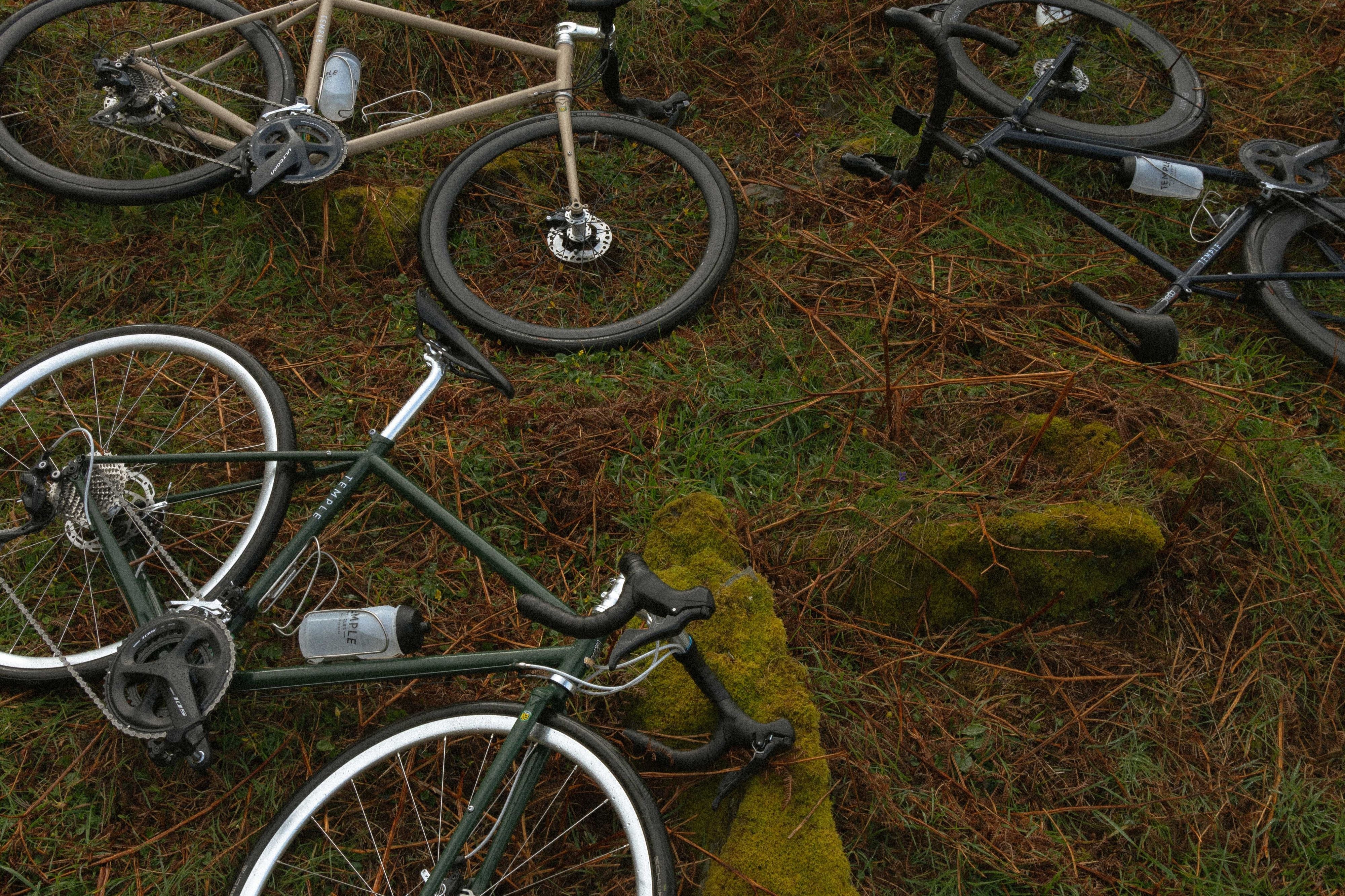 Birds-eye view of three lightweight road bikes in a country-rural setting.