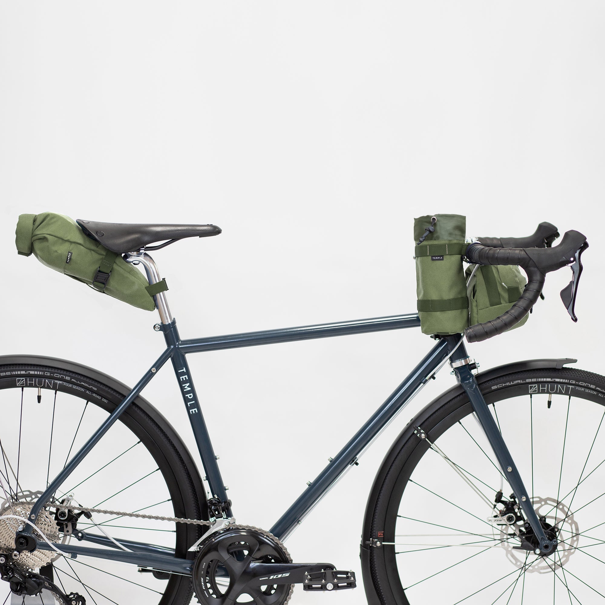 Durable roll-up bike bags attached to a lightweight, steel bike, studio setting.