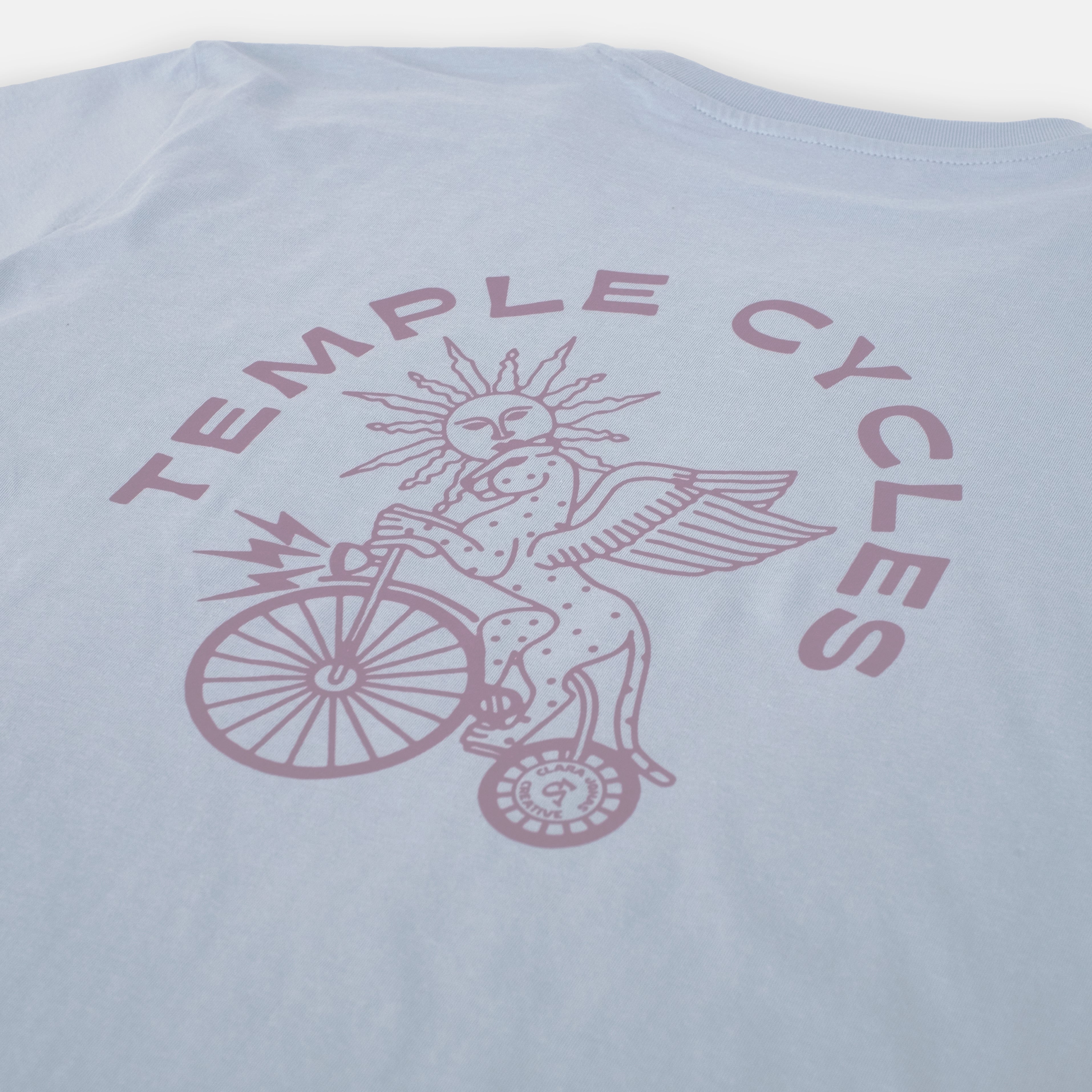 Clara Jonas X Temple Cycles unique graphic on light blue T Shirt, studio setting. 