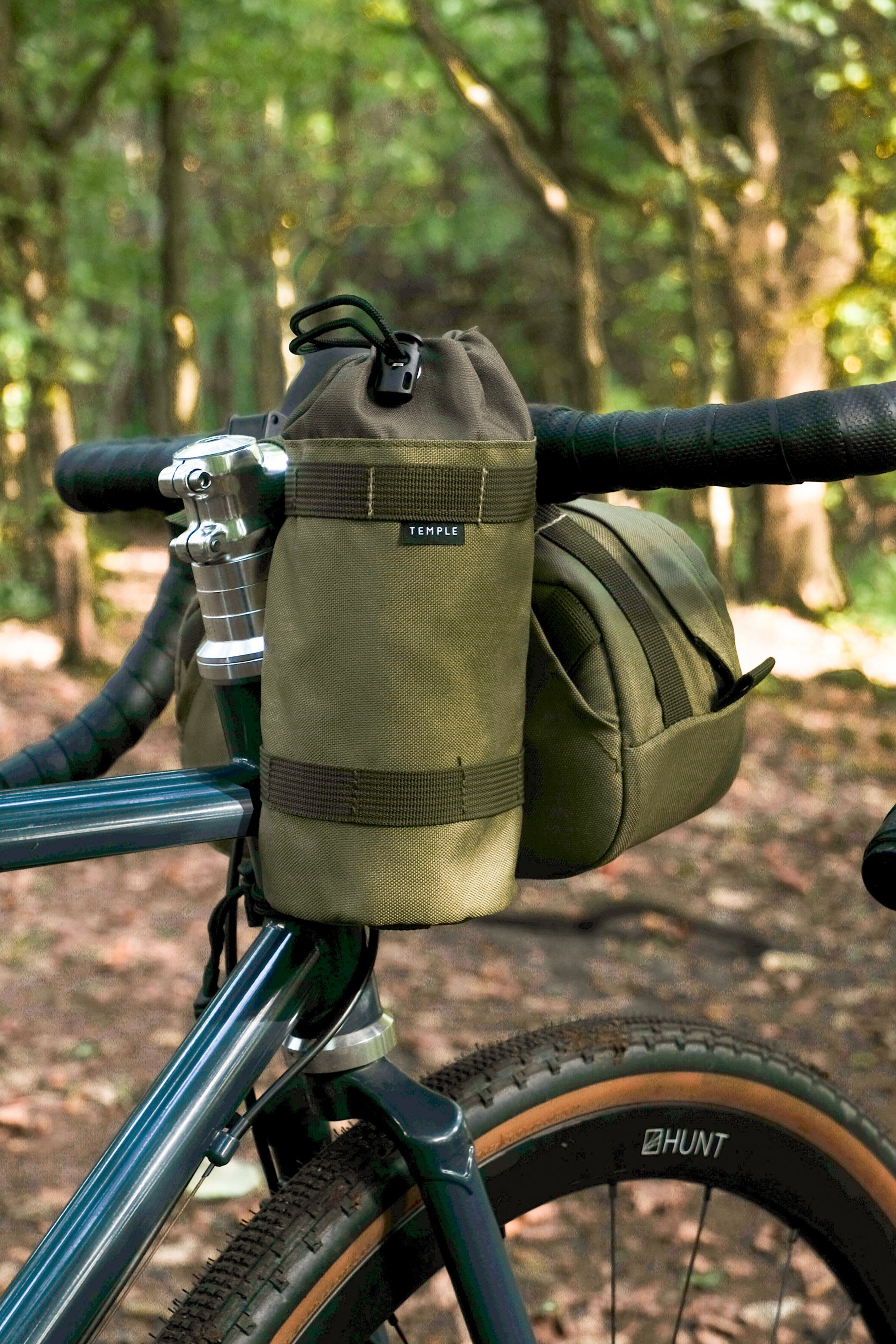 Fastened green snack bag attached to bike handlebars with a waterproof bar bag.