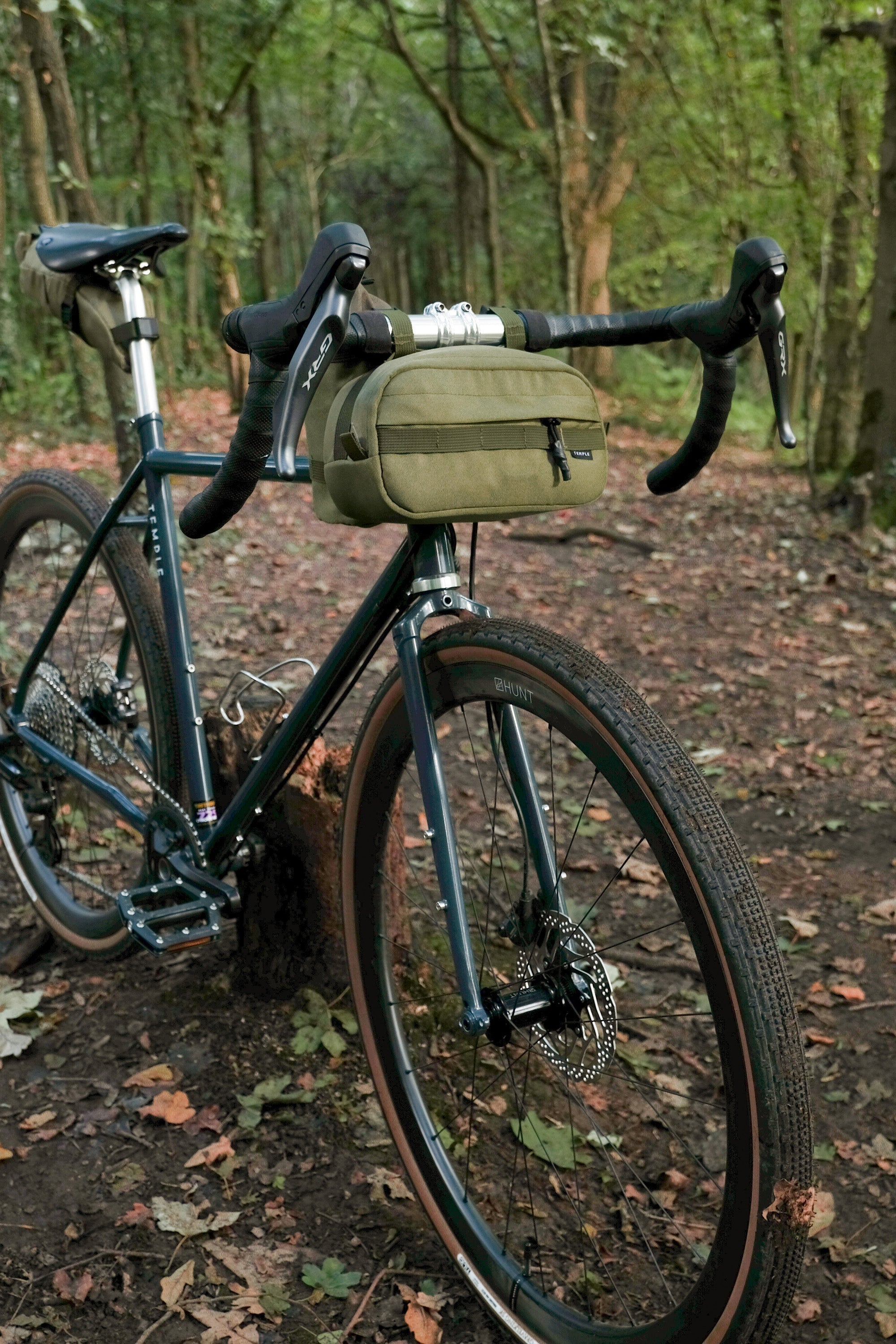 Commuter bum bag attached to adventure bike, forest setting.