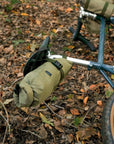 Bikepacking bicycle laying with three waterproof travel bags attached, rural setting.