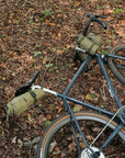 Three bike touring bags attached to hybrid bike, forest floor setting.