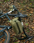 Bike laying on forest ground with three waterproof bike bags attached.