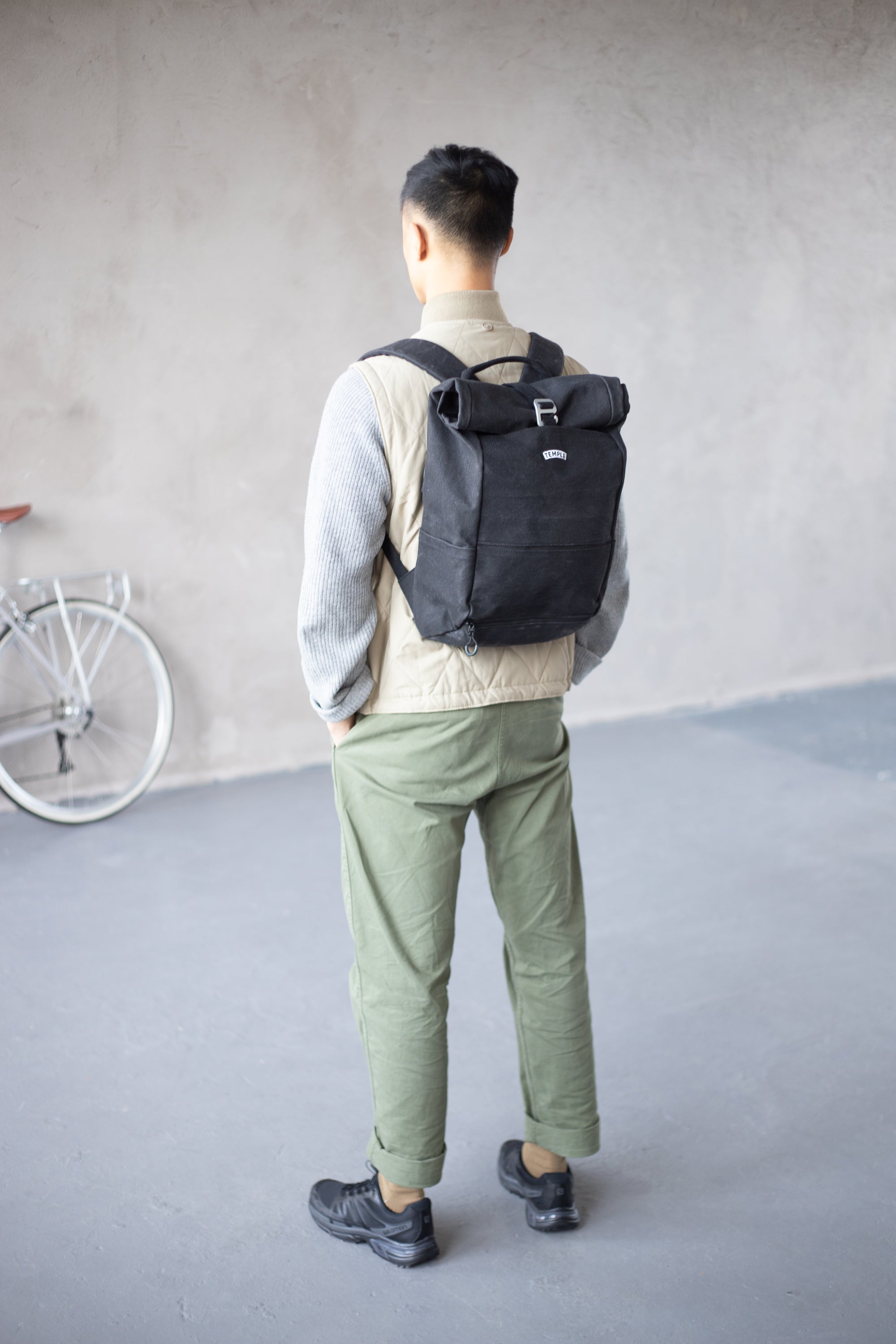 Model wearing black pannier backpack in an urban setting.