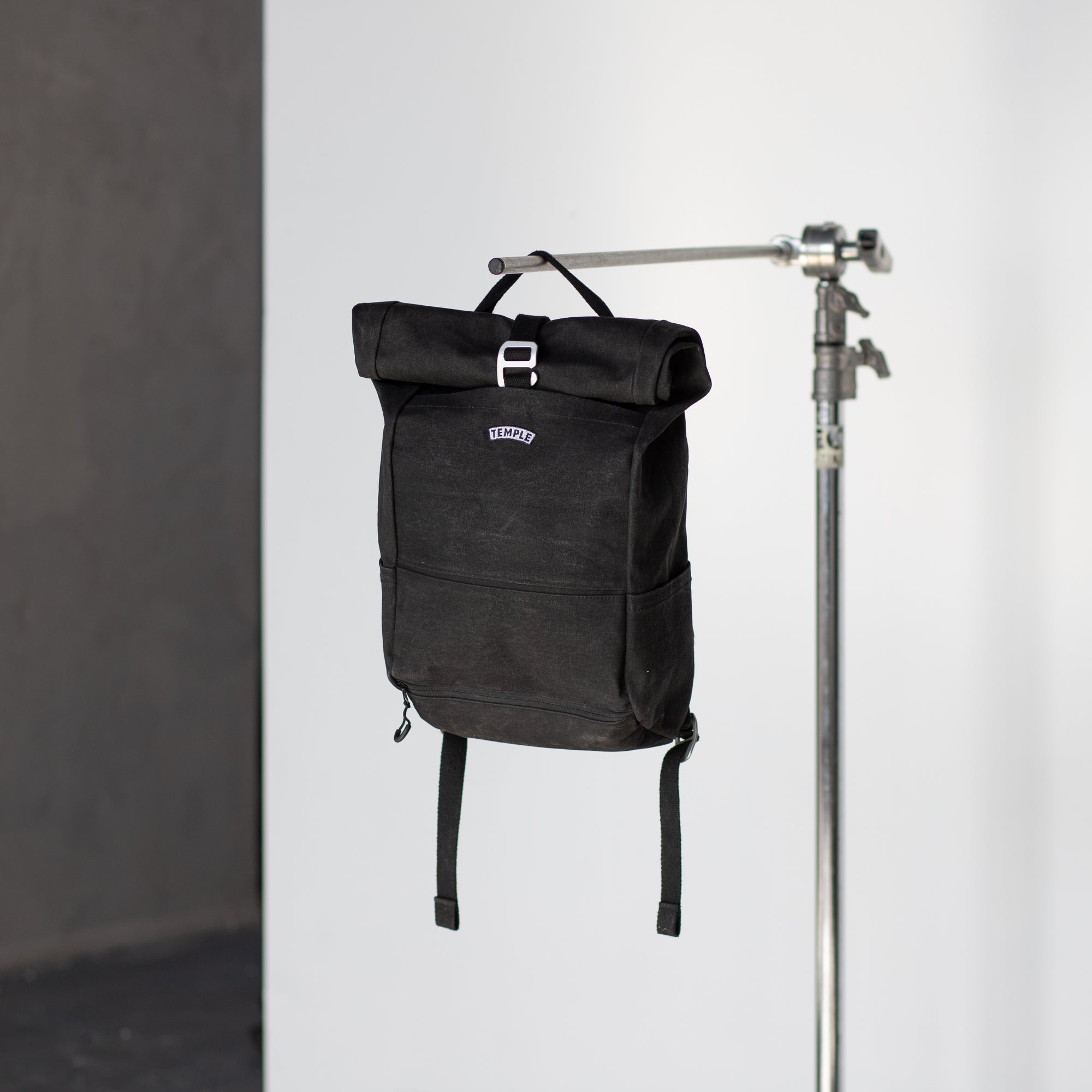 Black backpack for a pannier bike rack in a studio setting.