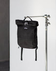 Black backpack for a pannier bike rack in a studio setting.