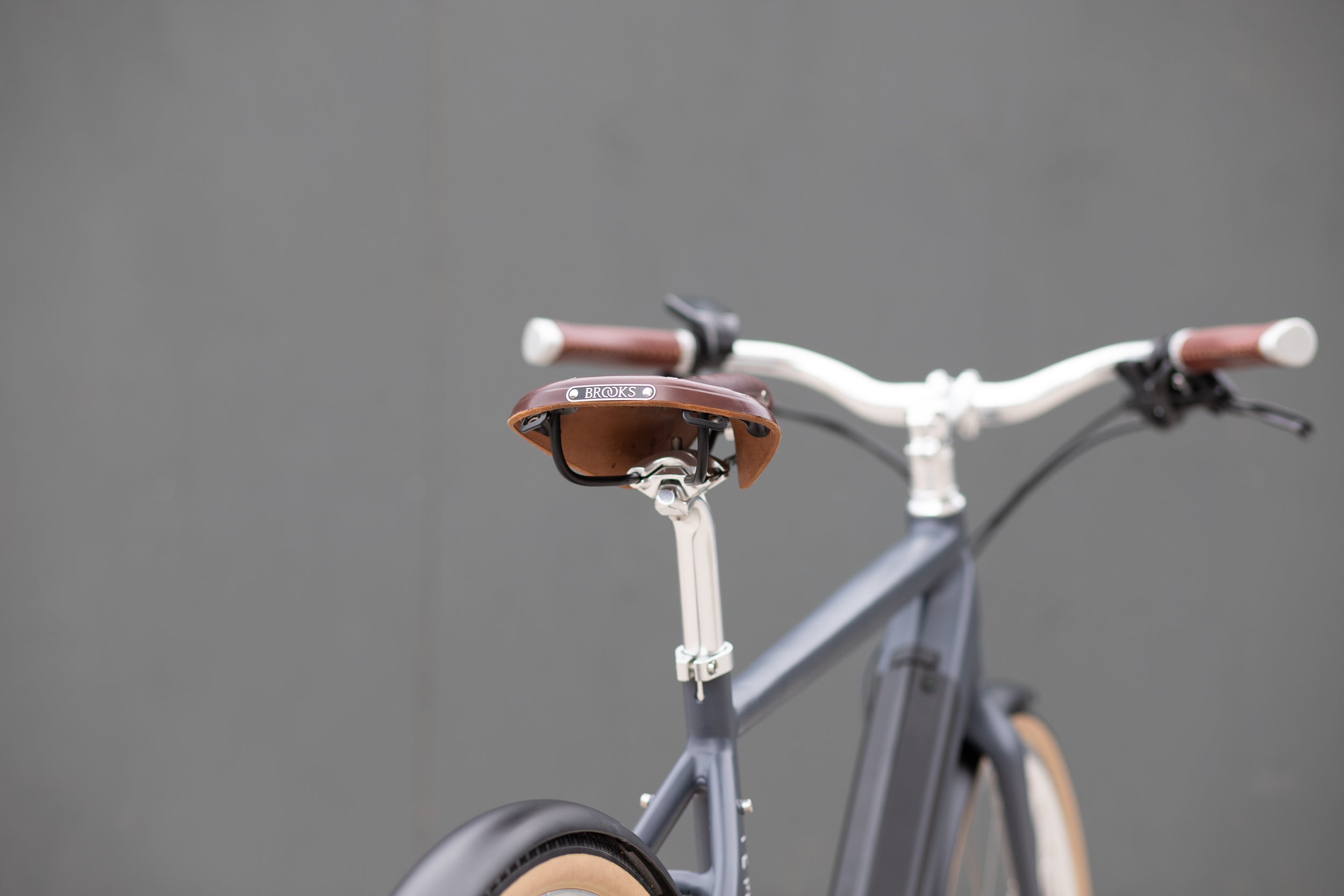 Rear view of Brooks leather saddle on an all-rounder city e-bike in black.