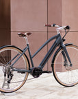 Step Through electric dark blue bike, urban setting. 