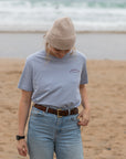 Female model facing camera with Temple Cycles super soft graphic tee in blue.