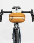 Front view of a premium bicycle bar bag attached to bike handlebars, studio setting.