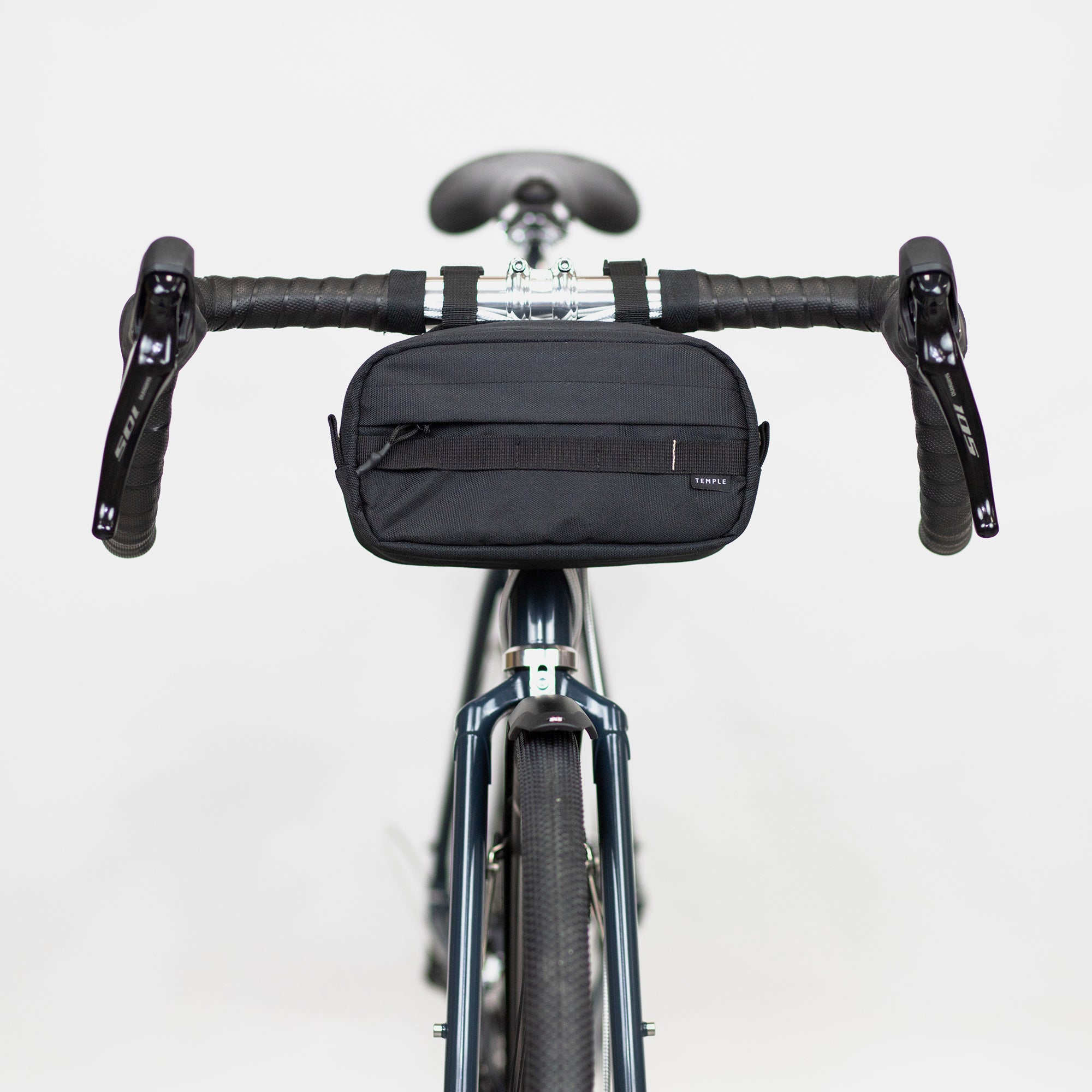 Front view of premium cycling bag in black attached to bike handlebars, studio setting.