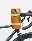 Un-rolled Temple snack bag attached to bicycle handlebars, studio setting. 