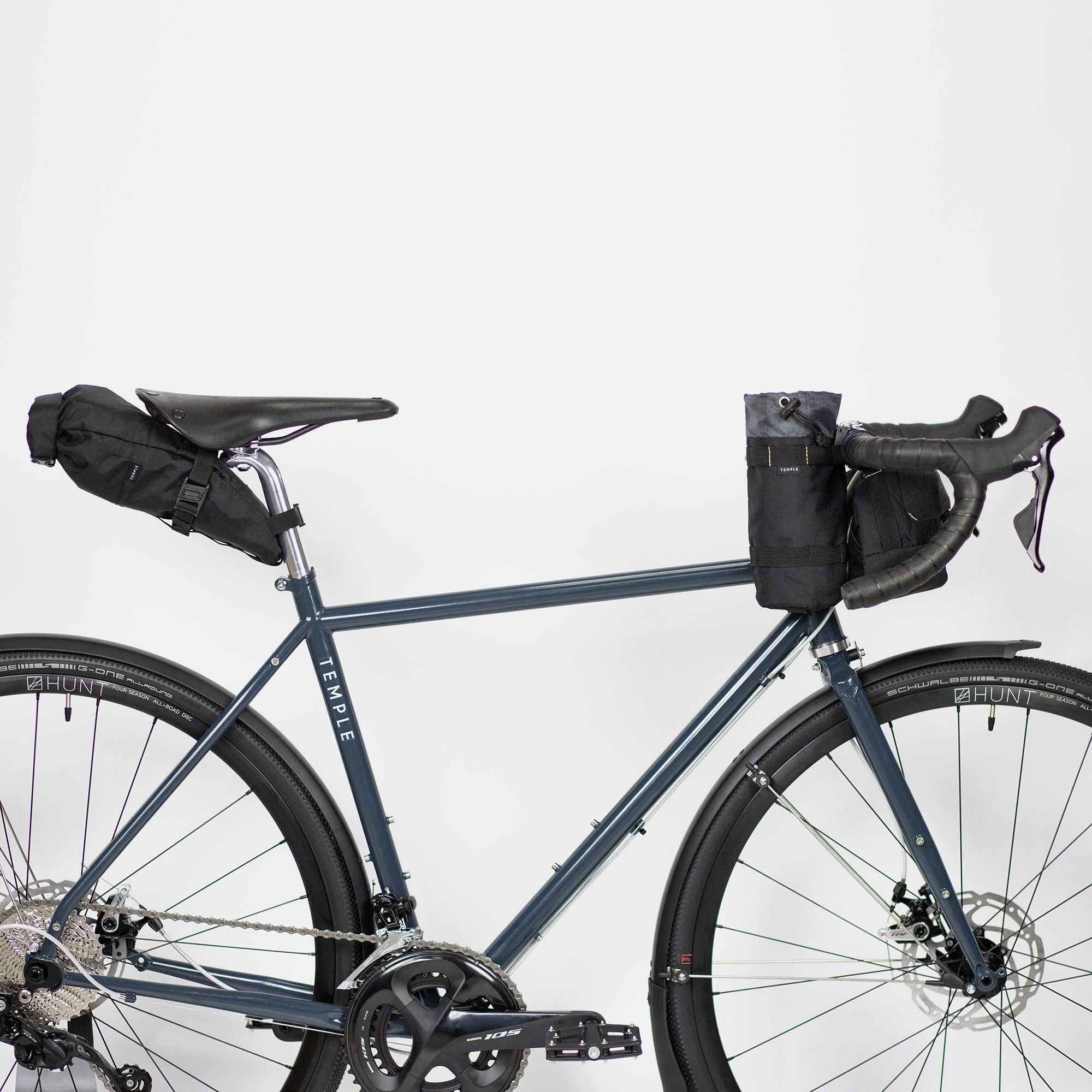 Three dusky black premium cycling bags attached to a Temple bicycle, studio setting.