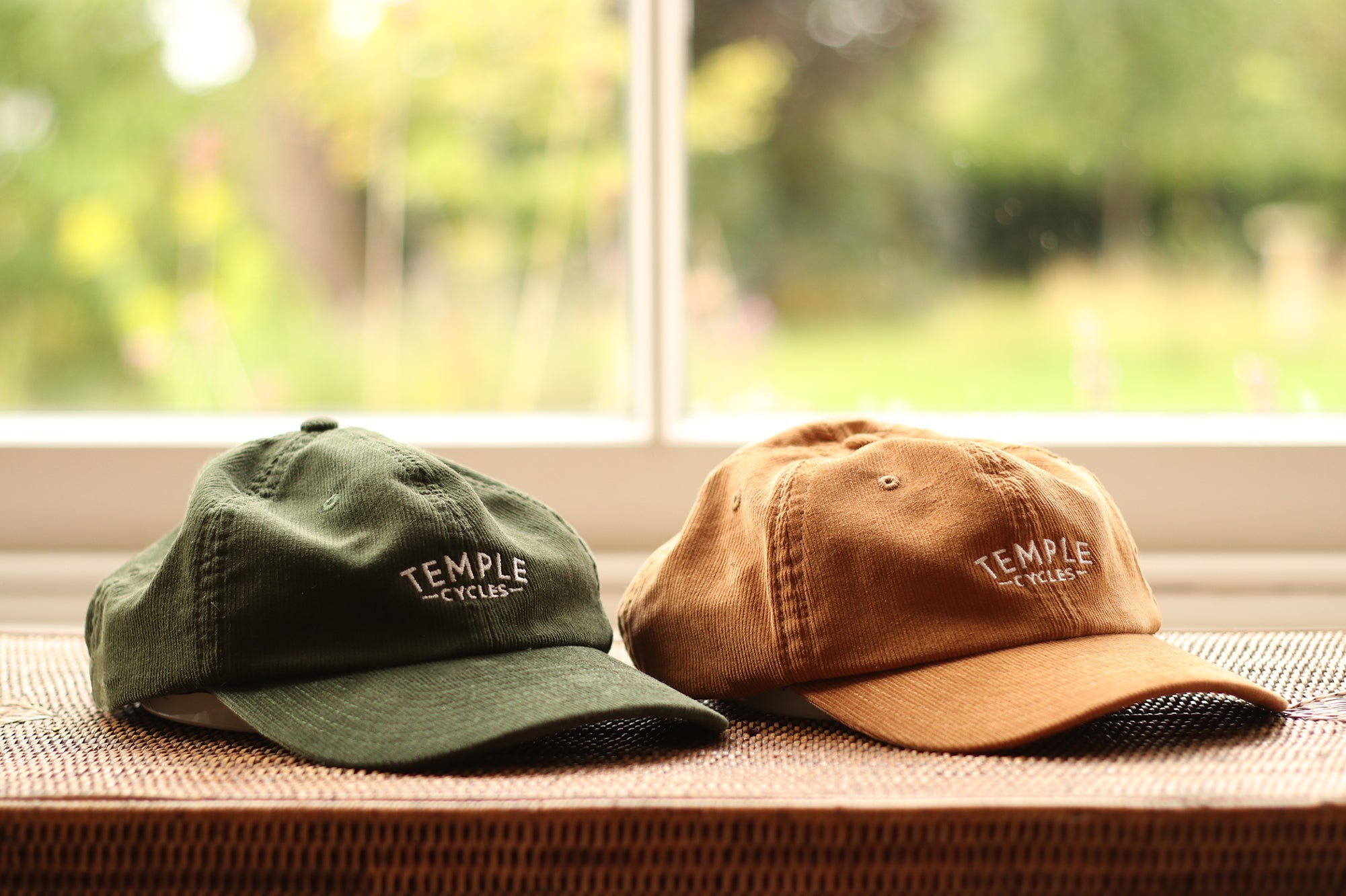 Dark green and brown corduroy caps with embroidered Temple logo, window setting.