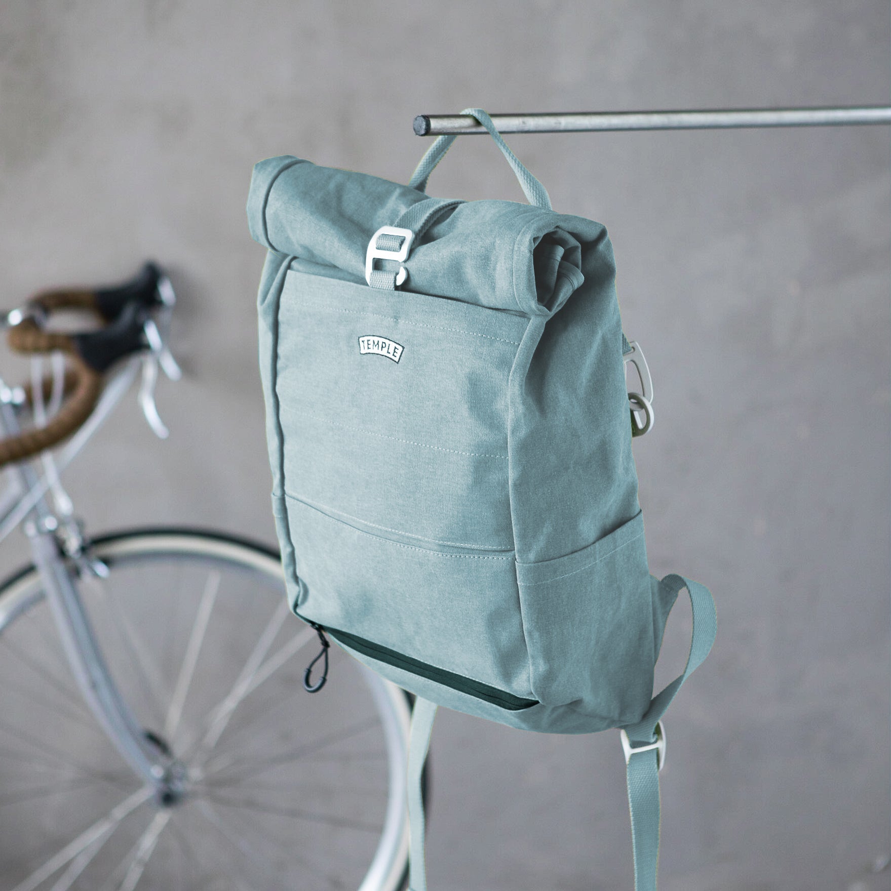 Teal waterproof bicycle Pannier backpack, urban setting.