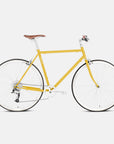 Mustard yellow steel bicycle in a studio setting.