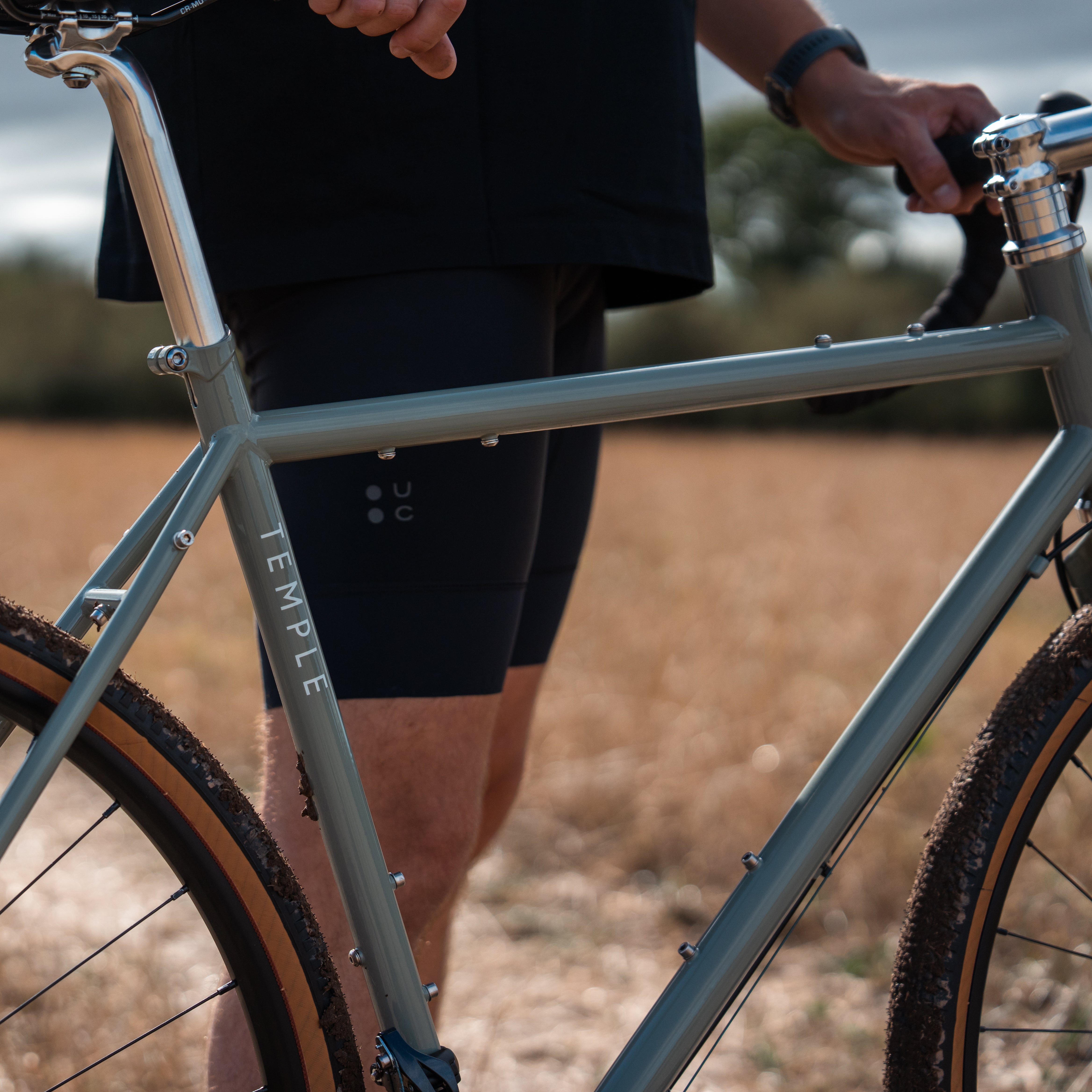 Person holding a bicycle with &#39;Temple&#39; branding in an outdoor setting