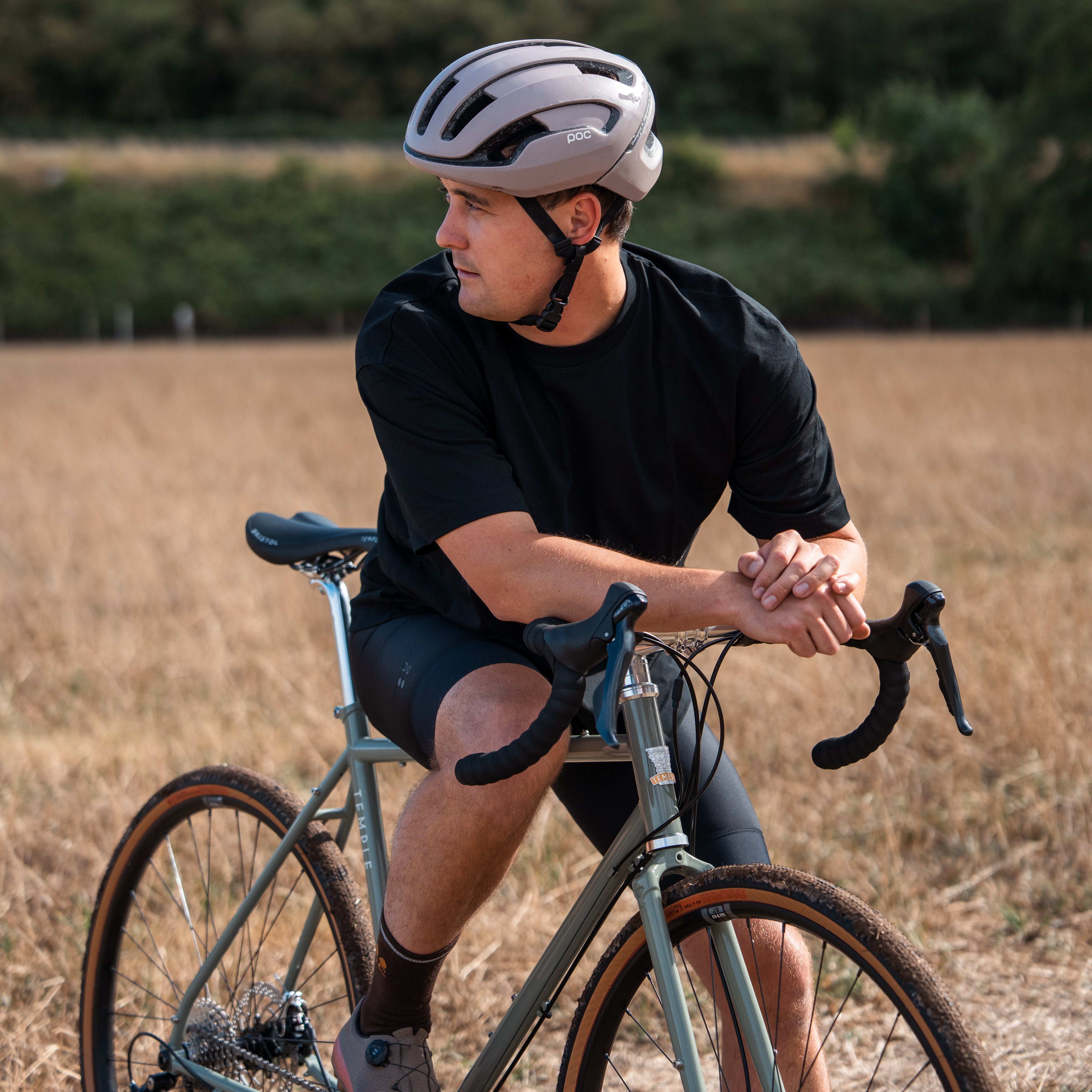 Man riding a bicycle in a field wearing a helmet