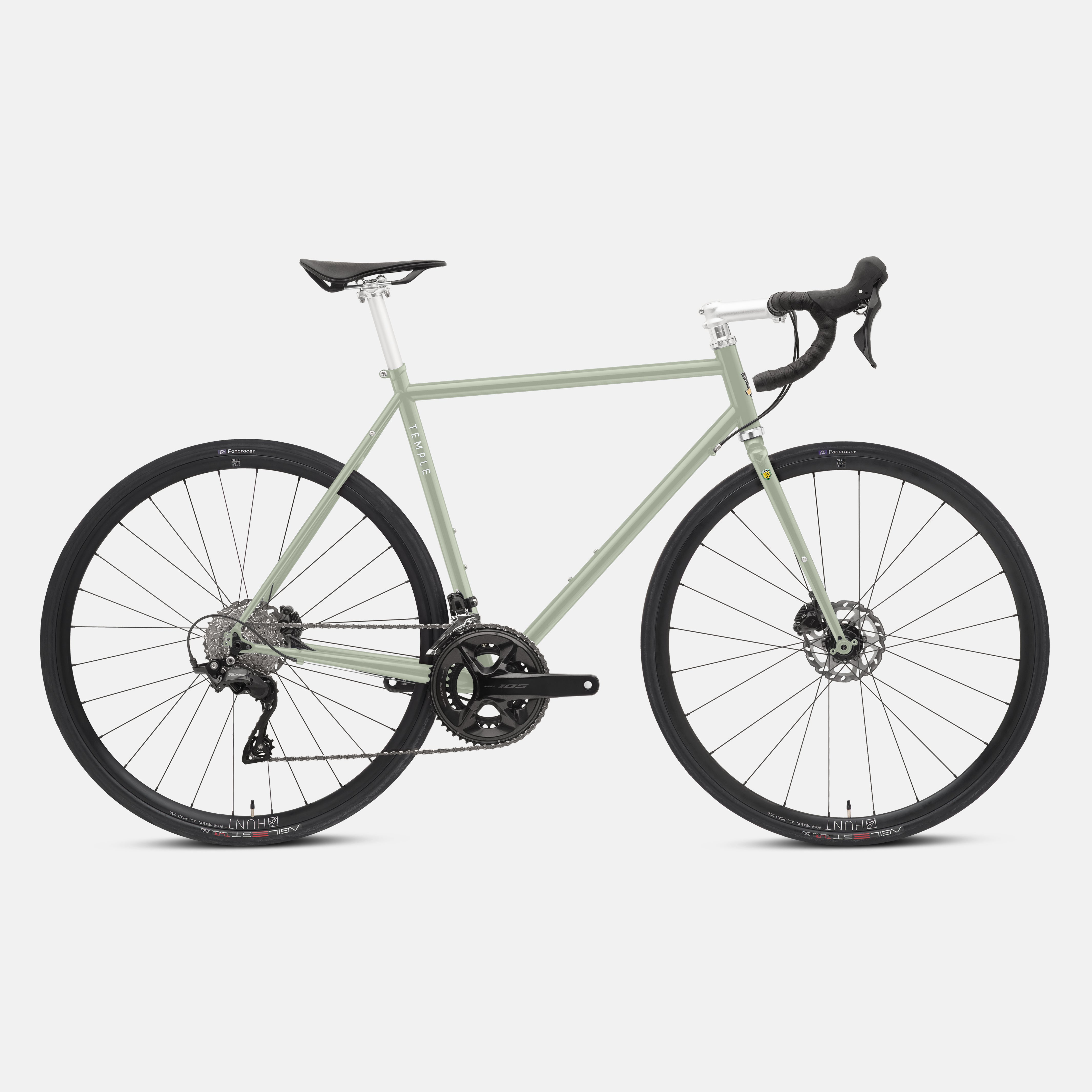 Green road bike with a steel lightweight frame, studio setting.