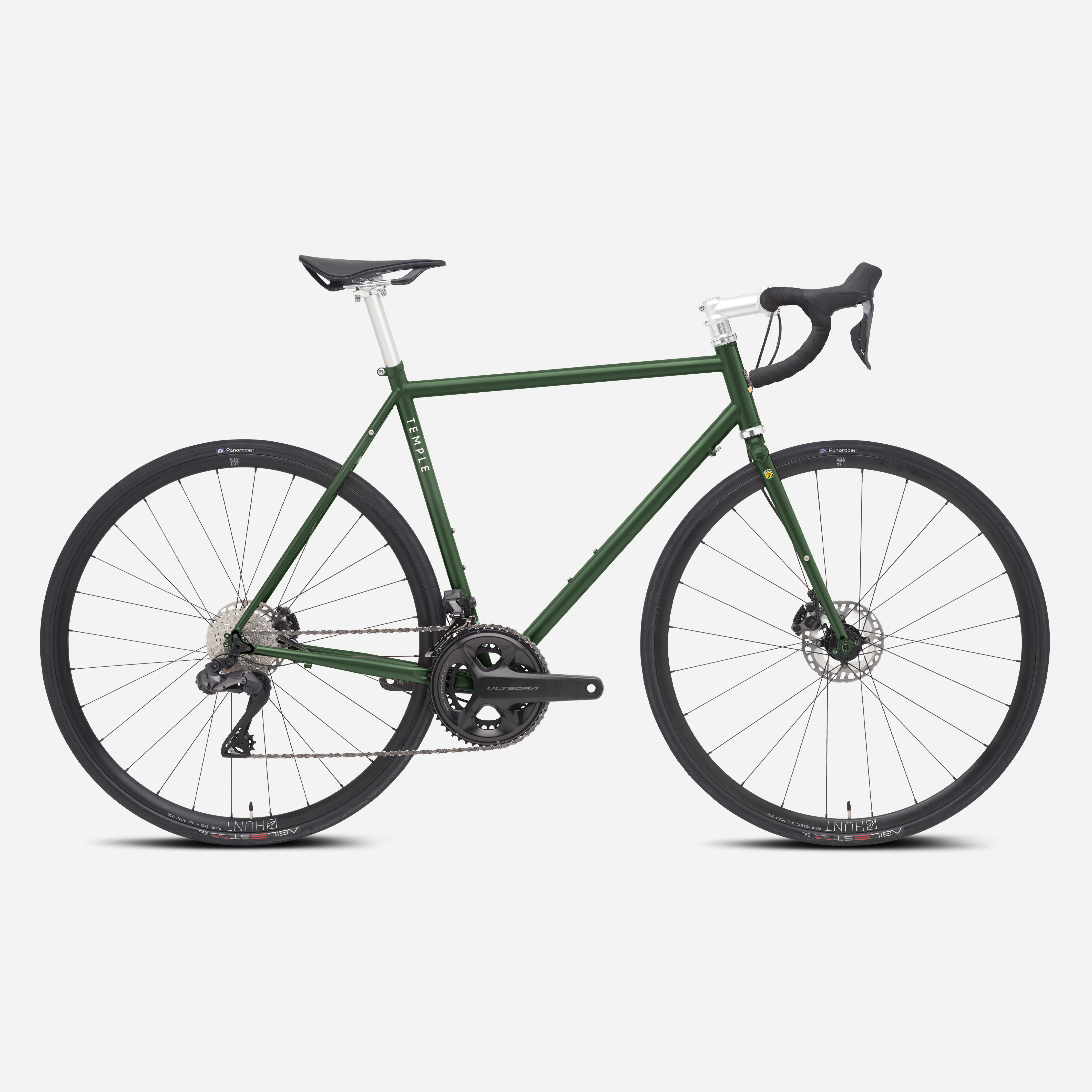 Dark green functional road bike with a lightweight steel frame, studio setting.